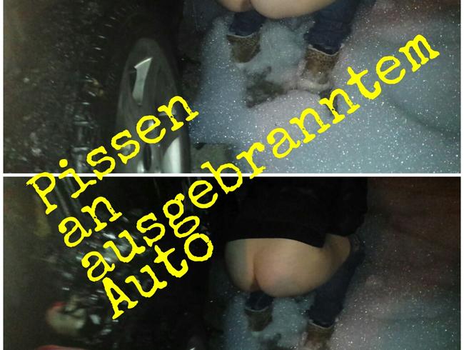 neben ausgebrantem Auto gepisst